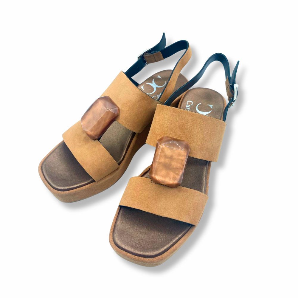 Costado sandalias de ante color cuero con joya de Plumers Menorca. Sandalias de ante color cuero con joya en el empeine, tira con hebilla al talón y suela de plataforma con cuña.