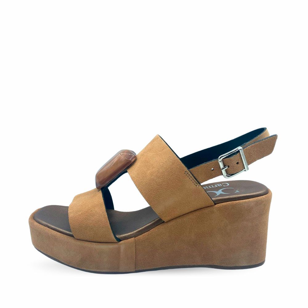 Sandalias de ante color cuero con joya en el empeine, tira con hebilla al talón y suela de plataforma con cuña.