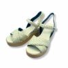 Sandalias de piel trenzada color beige, cierre con hebilla y suela de plataforma con cuña.