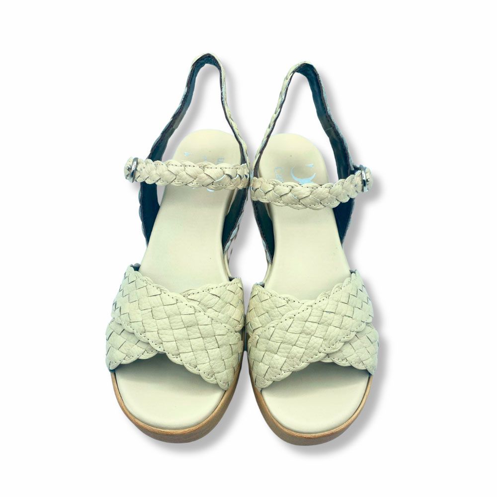 Sandalias de piel trenzada color beige, cierre con hebilla y suela de plataforma con cuña.