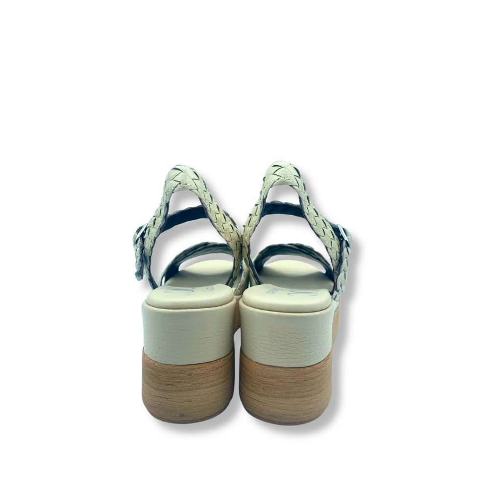 Sandalias de piel trenzada color beige, cierre con hebilla y suela de plataforma con cuña.