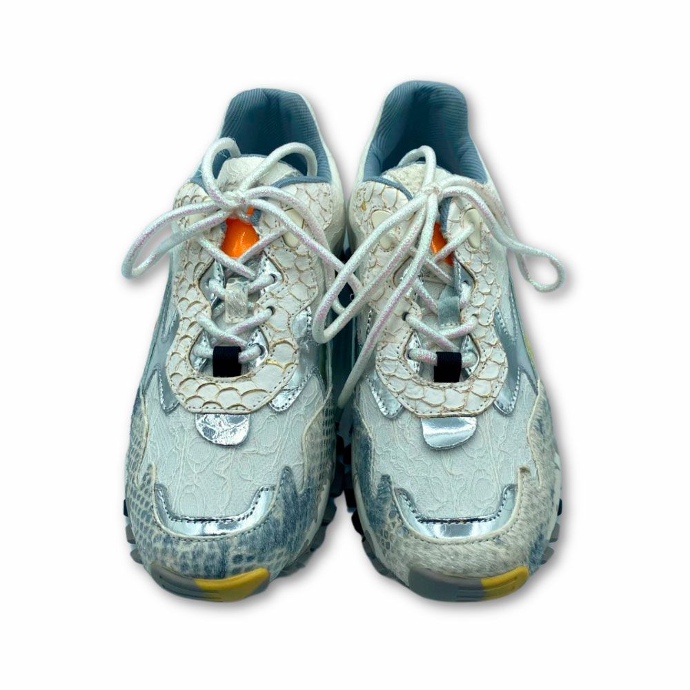 Deportivas con encaje color blanco y detalles en color azul en refuerzos. Suela de goma con tacos y letras de Exé.
