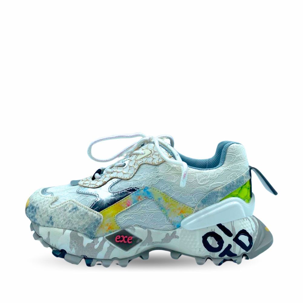 Deportivas con encaje color blanco y detalles en color azul en refuerzos. Suela de goma con tacos y letras de Exé.