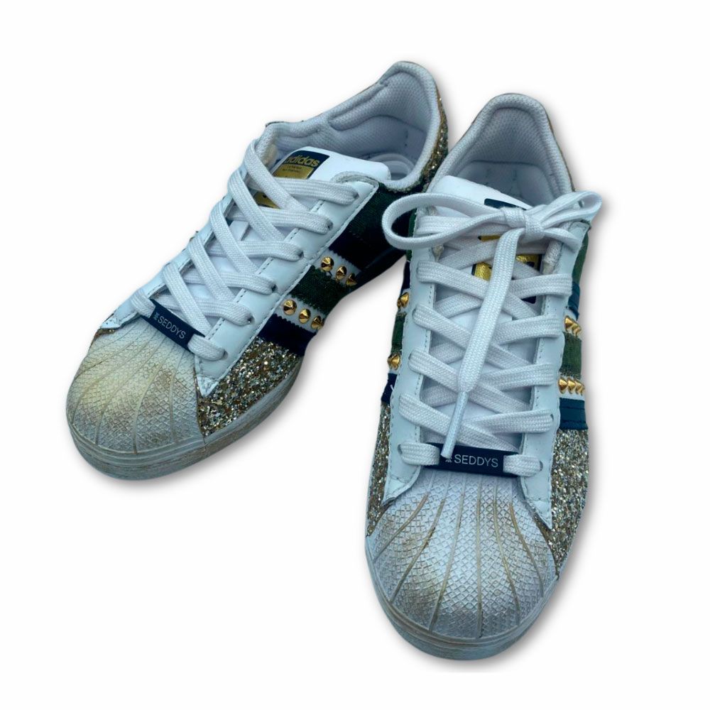 Costado originales zapatillas Adidas customizadas en dorado con brillo, remaches y estrella. Originales zapatillas Adidas customizadas con brillos, remaches y estrella dorados.