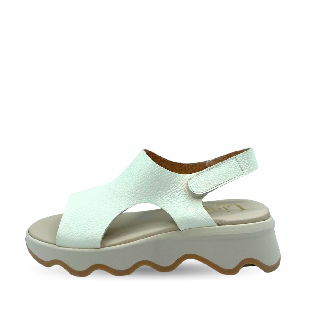 Sandalias blancas de piel y suela de cuña en goma ligera con ondulaciones de Ezzio.